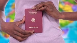 Frau hält deutschen Reisepass in ihren Händen