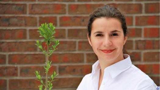 Friederike Fabianatz blickt lächelnd in die Kamera. Sie trägt eine weiße Bluse.