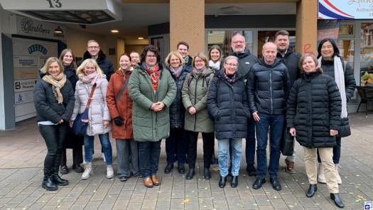 Eine Gruppe von Menschen steht in dicken Winterjacken in der Eberbacher Fußgängerzone.