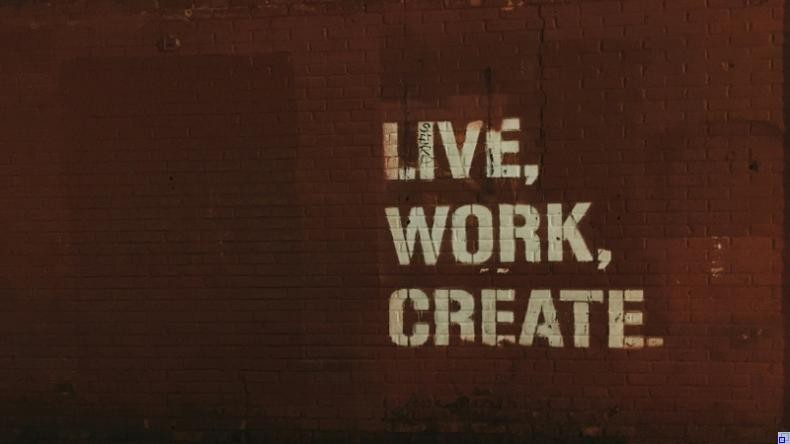 Bild: Jon Tyson / Unsplash rote Backsteinmauer; darauf ein Graffiti mit den Worten "Live, Work, Create".