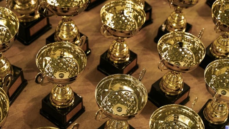 Bild: Unsplash mehrere Reihen goldener Pokale