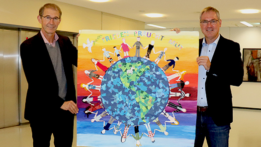 Landrat und Bürgermeister halten das bunte Plakat in den Händen