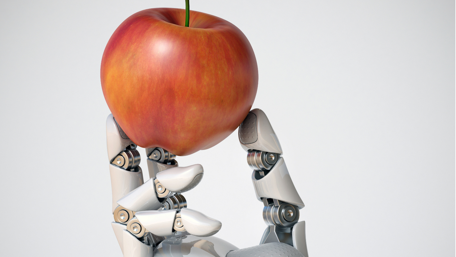 Roboterhand hält einen Apfel