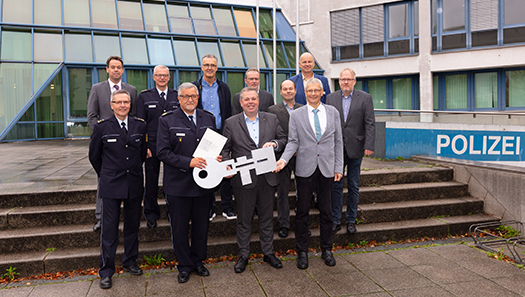 Symbolische Schlüsselübergabe vor dem Gebäude der Polizei