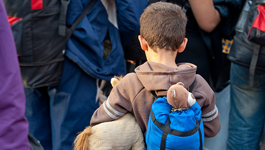 Kleiner Junge mit Rucksack und Teddybär