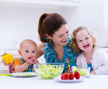 Mutter mit zwei kleinen Kindern beim Essen