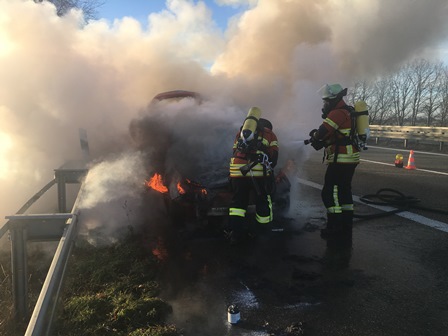 Feuerwehrmänner löschen den Brand eines Fahrzeugs