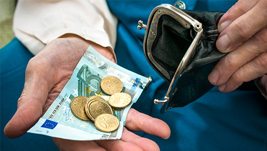 Geöffnete Geldbörse mit Münzen und einem 5 Euro Schein