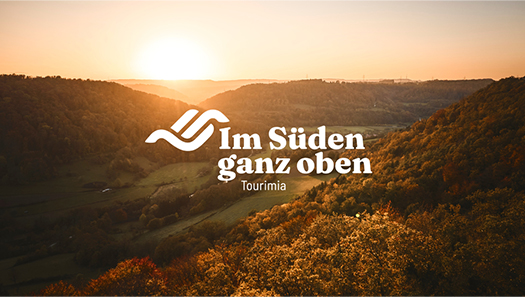 Hügellandschaft im Abendlicht - darüber das Logo Im Süden ganz oben
