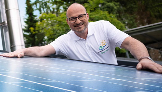 Mann beim Installieren einer Photovoltaik-Anlage auf den Dach.