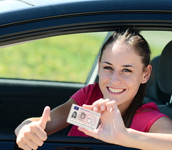 Junge Frau präsentiert lächelnd ihren EU-Führerschein