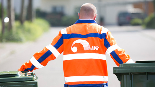 Müllwerker schiebt zwei Abfalltonnen