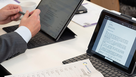 Sitzungsteilnehmer mit Dokumenten und Tablet