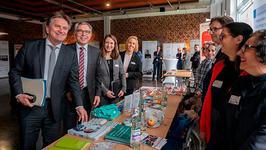 Verantwortliche stehen vor einem Infostand