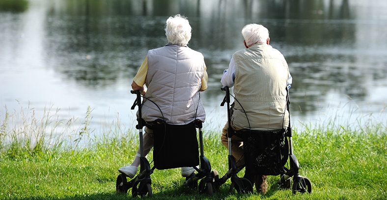 2 Senioren mit Rollator an einem See