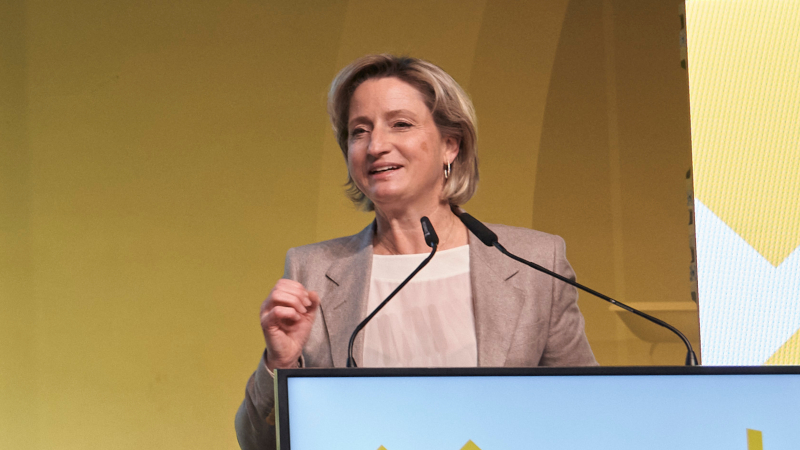 Ministerin steht hinterm Redepult und spricht.