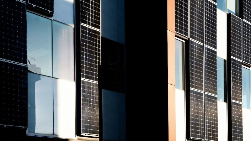 Fassade eines Bürogebäudes, einige vertikale Flächen sind mit Solarpaneelen verkleidet.