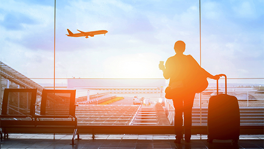 Silhouette einer Frau mit Koffer am Flughafen-Gate