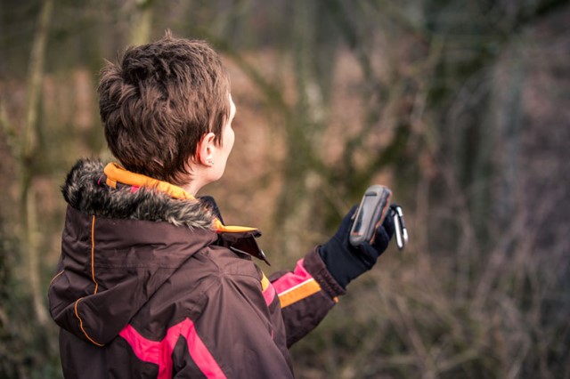 Junge Frau beim Geocaching