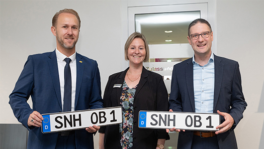 das SNH-Kennzeichen wird von drei Personen präsentiert